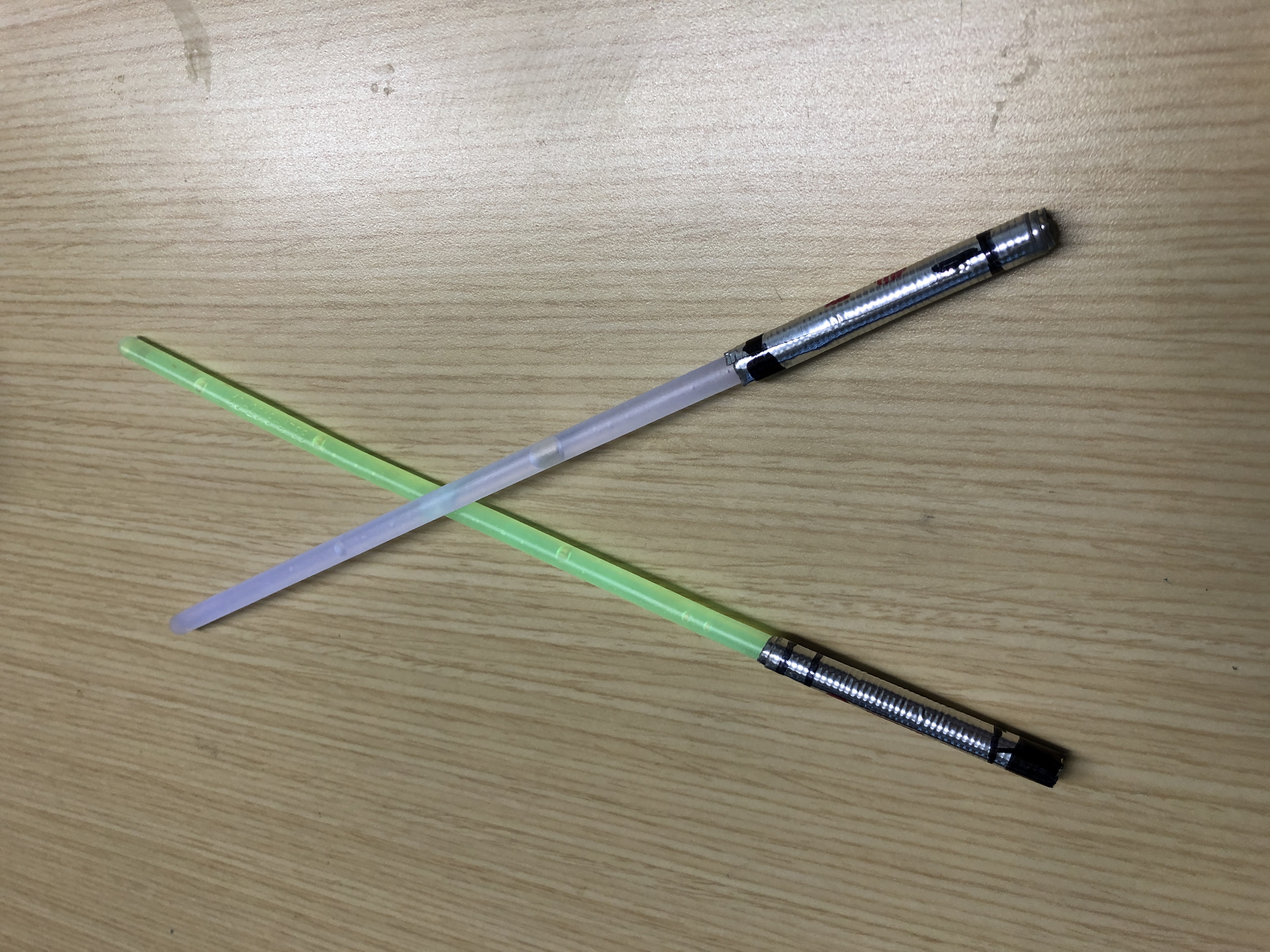 glow sticks with silver tape on the bottom mimicking light sabers