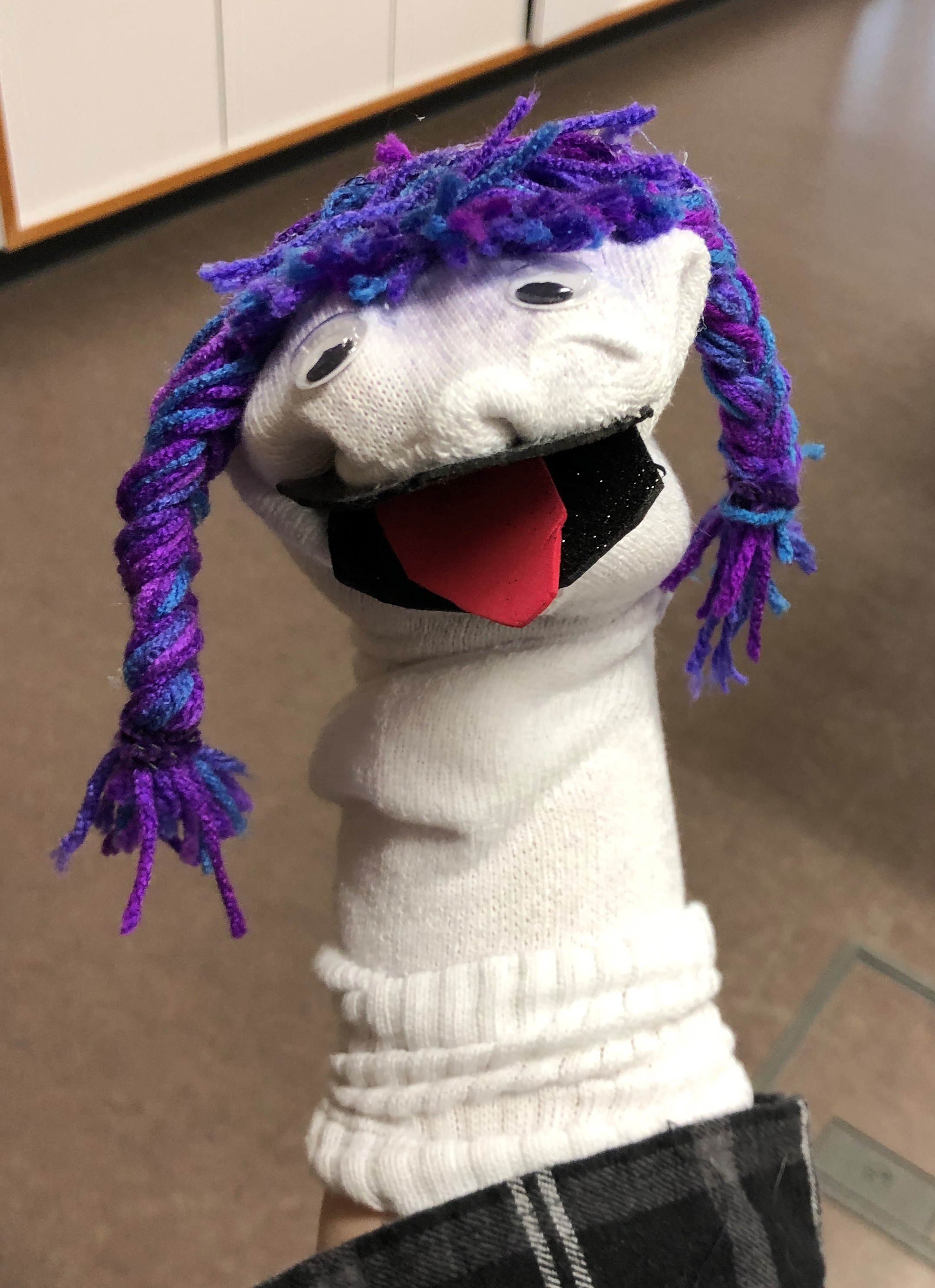 white sock puppet with purple hair