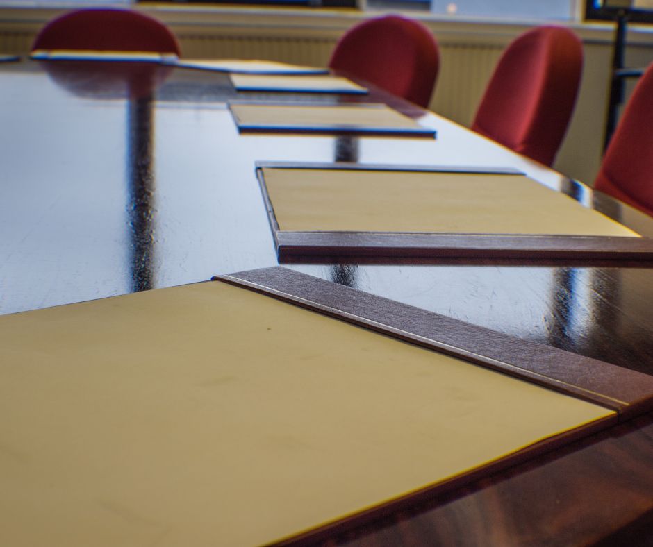 Empty board room table with chairs and placemats