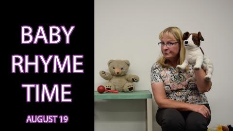 A woman holds a dog puppet next to a text overlay that says "Baby Rhyme Time August 19"