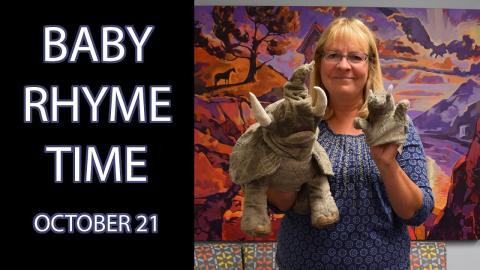 A woman holds two elephant puppets next to the text "Baby Rhyme Time October 21"