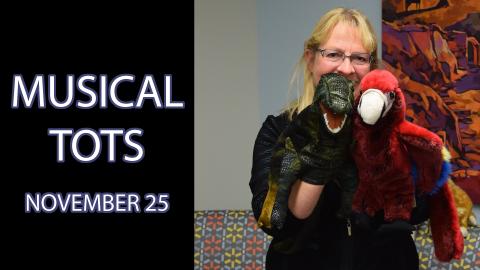 A woman holding puppets, standing next to the text "Musical Tots November 25"