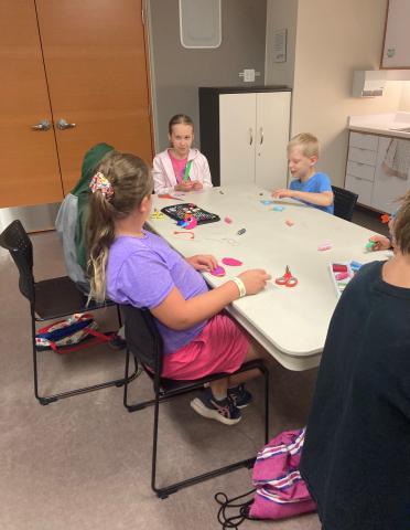 Children sewing birds to attach to key chains.