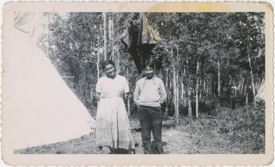 Image of Indigenous couple beside a teepee. Photo from South Peace Regional Archives. 