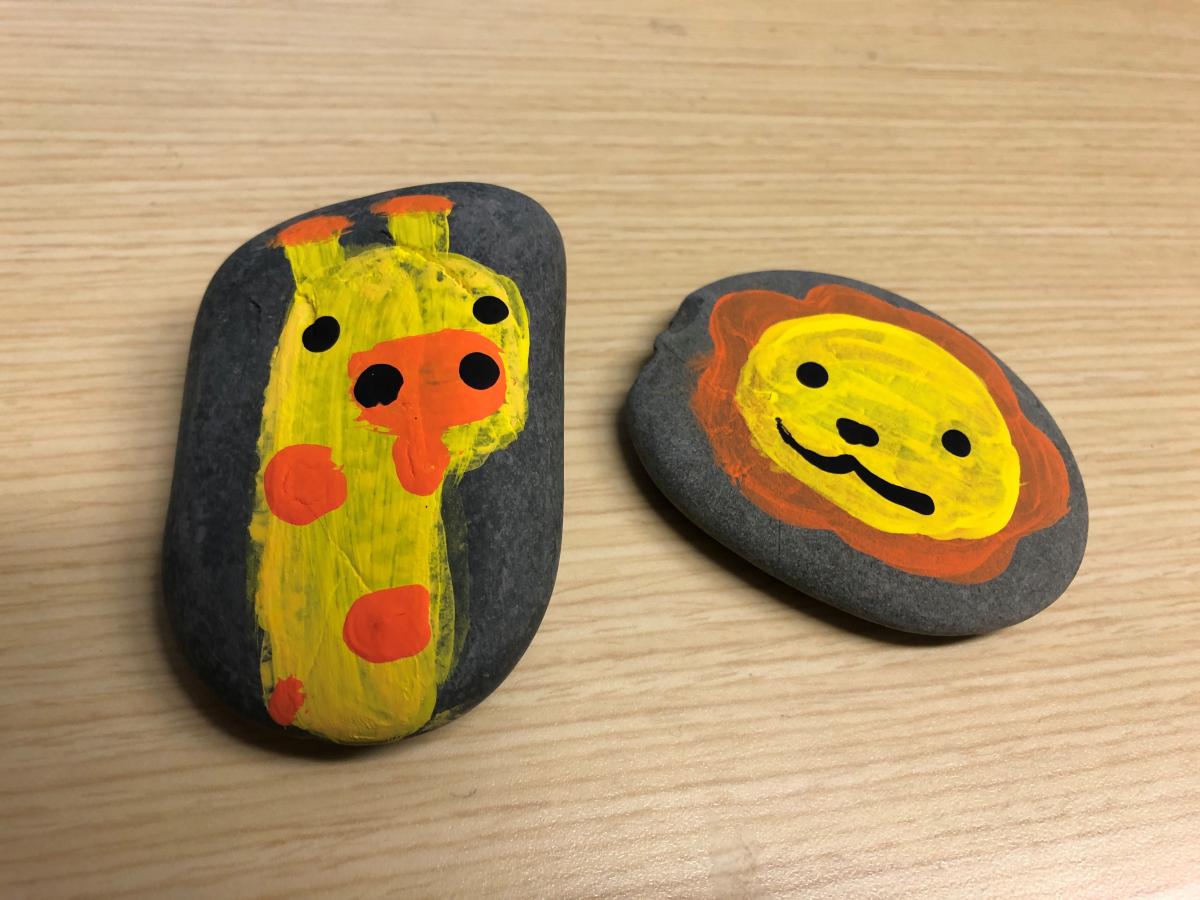 Cartoon giraffe and lion painted on rocks